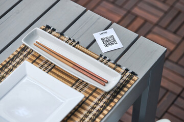 QR code of menu and chopsticks on table in restaurant