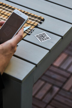 Crop man scanning QR code of restaurant menu