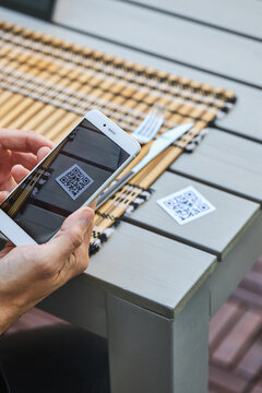 Crop man scanning QR code of restaurant menu
