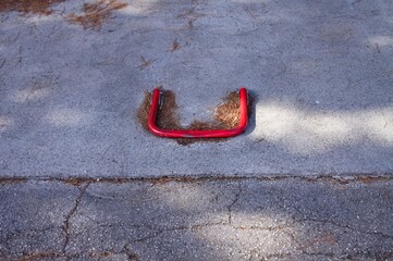 A red traffic bollard on the asphalt (Marche, Italy, Europe)