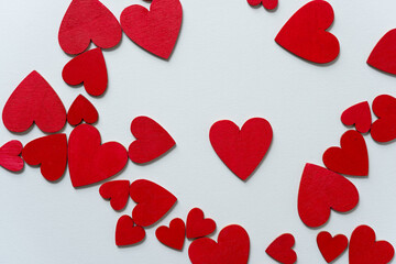 hand painted wooden shapes (hearts) in cadmium deep red acrylic paint on a light background - photographed from above with ambient light