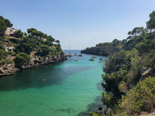 Cala Pi bay in the southern part of Mallorca with crystal clear turquoise water and sailing yachts