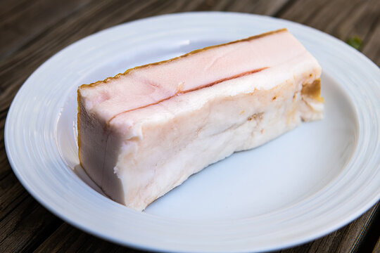 Closeup of traditional salted pork belly fat food for making sandwiches from slices of the lard as traditional Russian cuisine on plate