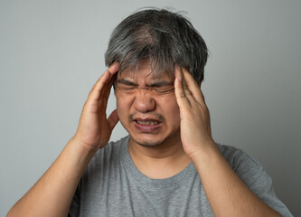 Sick Asian man wearing a medical face mask and Take a hand to hold the headache in the head. Concept of protection pandemic coronavirus and respiratory disease