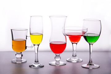 Different types of crystal glasses with colorful liquid inside