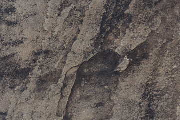 Grey and black rock texture. Natural stone background with copy space. Cracked weathered granite surface