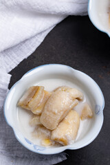 Banana in Coconut Milk , Thai Dessert (Kluay Buat Chi) on black background