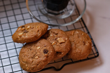 chocolate cookies on black grid, on white marble table, selective focus, horizontal, with copy space