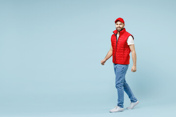 Full size body length professional delivery guy employee man in red cap white T-shirt vest uniform...