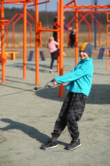 Obraz premium Nine year old happy caucasian boy working out on the outdoor sports ground