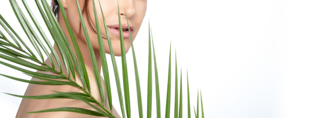 Beauty spa woman with green tropical leaf. Skincare and wellness concept
