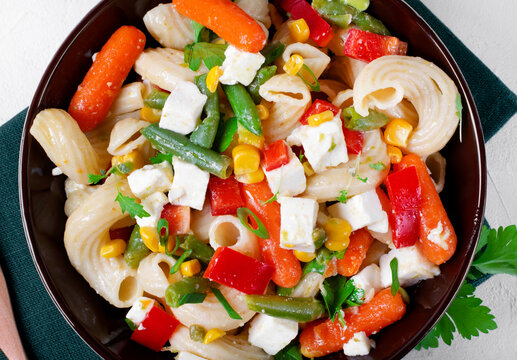 Pasta Salad With Green Beans, Baby Carrots, Bell Pepper, Corn And Feta Cheese. Mediterranean Cuisine Meal. Top View