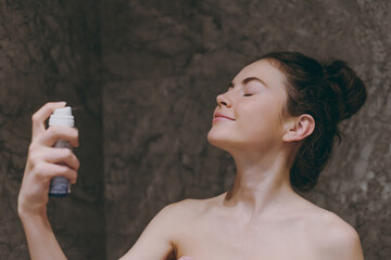 Side view half naked topless young satisfied woman 20s apply on fixative and make-up base on face...