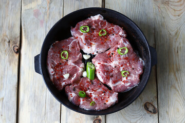 Raw steaks with spices in a cast iron grill pan. Cooking steaks.