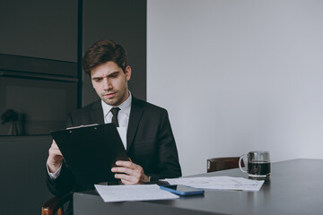 Bottom view serious smart young employee business man corporate lawyer in formal black suit shirt...