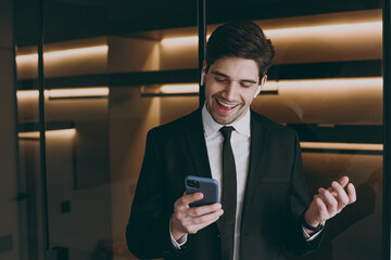 Succesful excited smiling employee agent business corporate lawyer 20s in black suit shirt tie air...