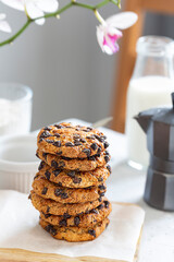 Cookies with chocolate pieces laid on a wooden board with a white napkin