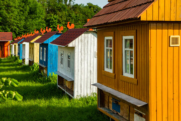 Colored bee houses on green meadow in countryside. Honey bee hives. Beautiful small decorative houses.