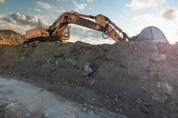 Excavator moving dirt and sand at a construction site