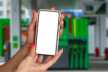 Mock up smartphone in hand closeup on the background of a gas station. Payment refueling online.
