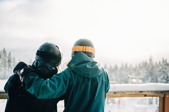 V&auml;nner st&aring;r tillsammans p&aring; terrass och tittar ut &ouml;ver skidby
