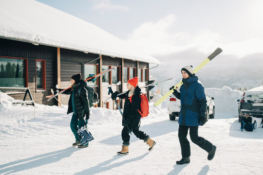 V&auml;nner g&aring;r med skidor p&aring; parkeringsplats