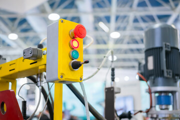 Machine control panel with push buttons and switches - emergency stop at factory, plant - close up. Industrial, electronic, technology equipment concept