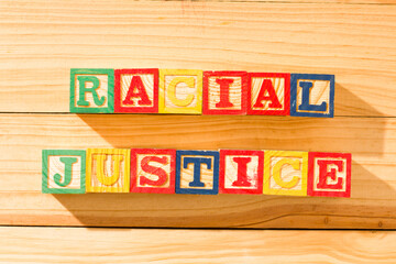 Spectacular wooden cubes with the word RACIAL JUSTICE on a wooden surface.