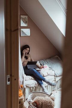 Kvinnlig entrepren&ouml;r sitter i s&auml;ng och pratar i mobiltelefon