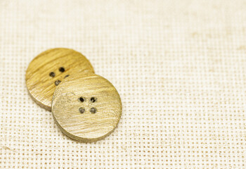 two wooden buttons lie on a burlap, a kind of super-. High quality photo