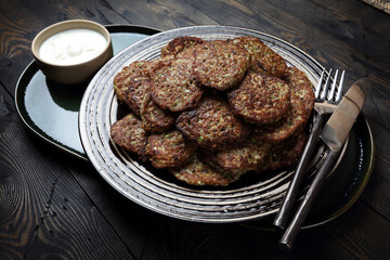 Homemade vegetarian zucchini and mushrooms pancakes served with unsweetened yogurt
