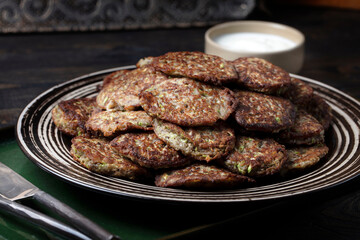 Homemade vegetarian zucchini and mushrooms pancakes served with unsweetened yogurt