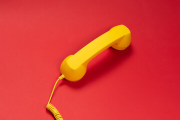 Yellow handset on red background.