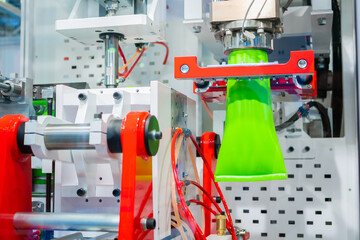 Manufacturing of empty green plastic jerrycans at factory, exhibition - automatic blow molding...