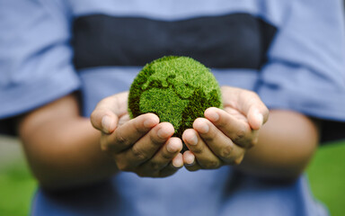 Close up of hands holding the earth on a green background. protect nature. Save Earth. concept of...