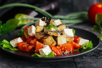 Salad with eggplants, tomatoes and feta cheese. Delicious salad on a plate