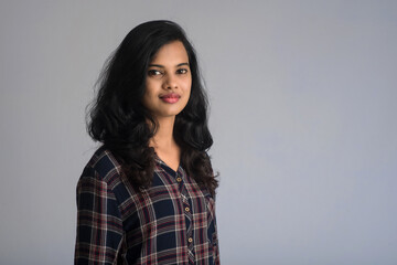 Obraz premium Portrait of a young beautiful cute cheerful girl smiling looking at the camera on gray background