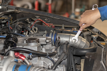 The mechanic is checking the engine.