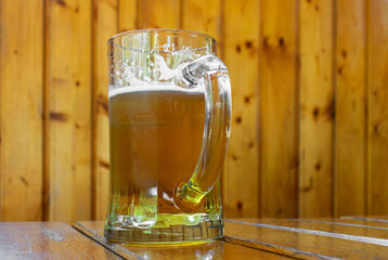 Beer mug in the bar. Wooden background.