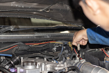 The mechanic is checking the engine.