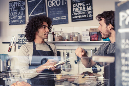 Man antecknar under diskussion med kollega p&aring; caf&eacute;