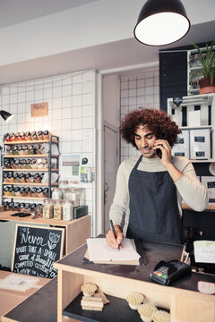 Manlig entrepren&ouml;r pratar i mobiltelefon och antecknar p&aring; papper