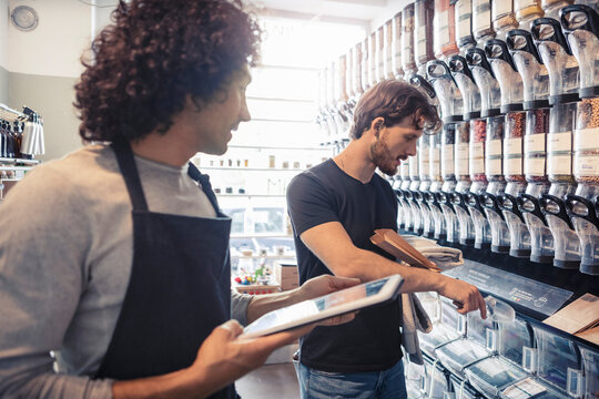 Manlig &auml;gare hj&auml;lper kund i ekologisk butik