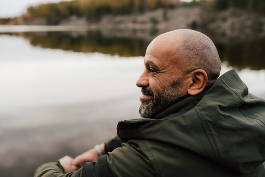 N&ouml;jd vandrare sitter p&aring; klippa och tittar ut &ouml;ver sj&ouml;