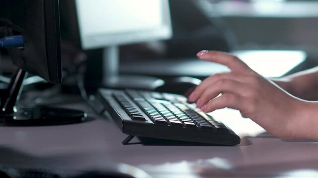 Call center and customer service assistance. customer support specialist in office types on the computer keyboard, advises client on phone.