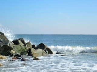 Ocean waves splashing on a stone jetty