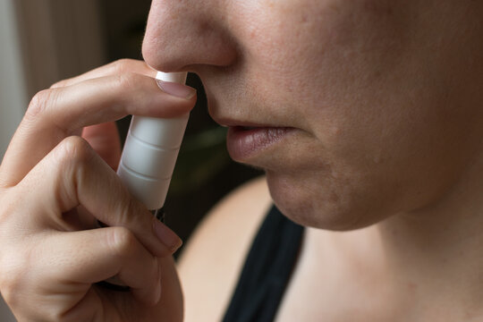 Woman In Profile Taking An Allergy Nasal Spray; Female Is 40 Years Old