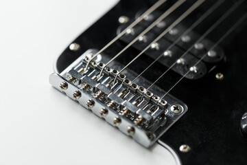 Electrical guitar bridge and metal strings closeup. Electric guitar black and white color, detail. Music instruments. Concept international music day