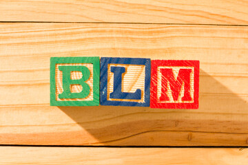 Spectacular wooden cubes with the word BLM BLACK LIVES MATTER on a wooden surface.