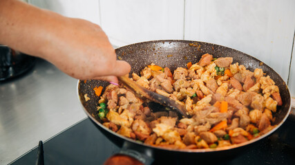 person cooking in a pot vegetables and chicken